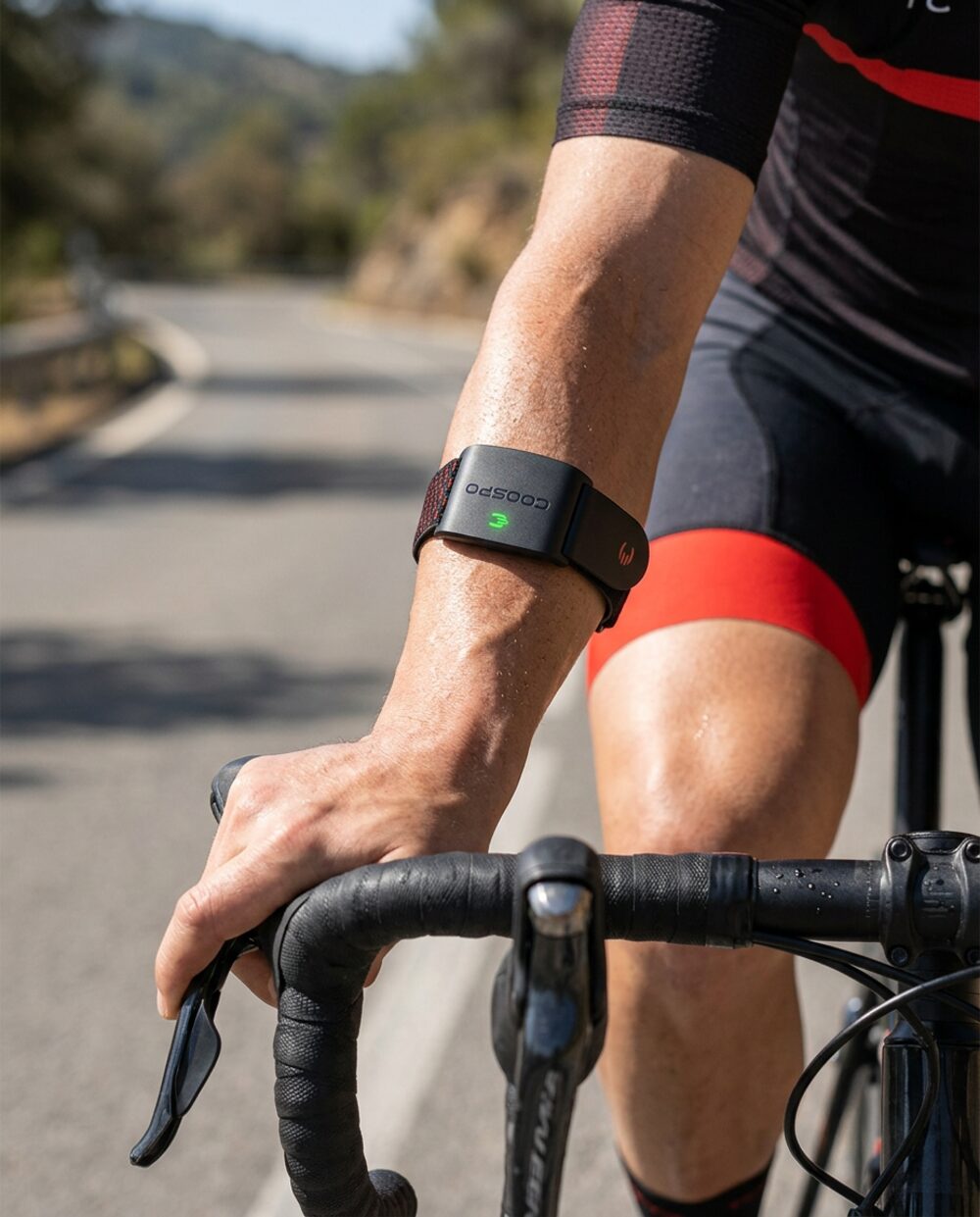 Cyclist on a road bike with the armband monitor on the forearm